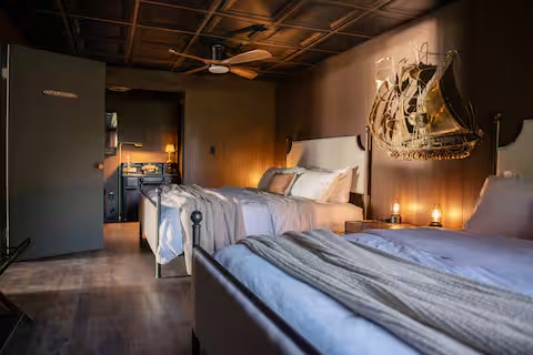 Bedroom with two king beds and warm nautical styling