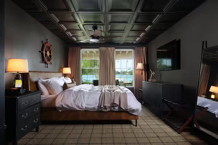 King bedroom with lake-facing windows and nautical details